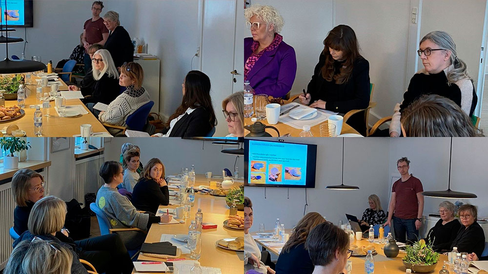 Mange personer rundt om et bord til en bestyrelseskonference